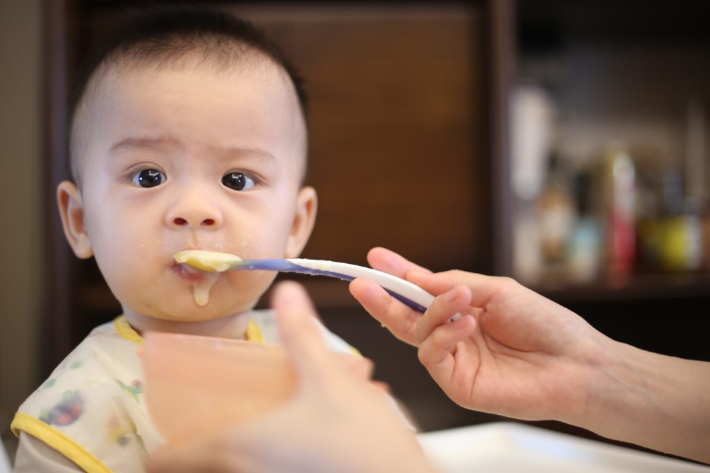 A photo of a baby eating and How often parents should feed their baby