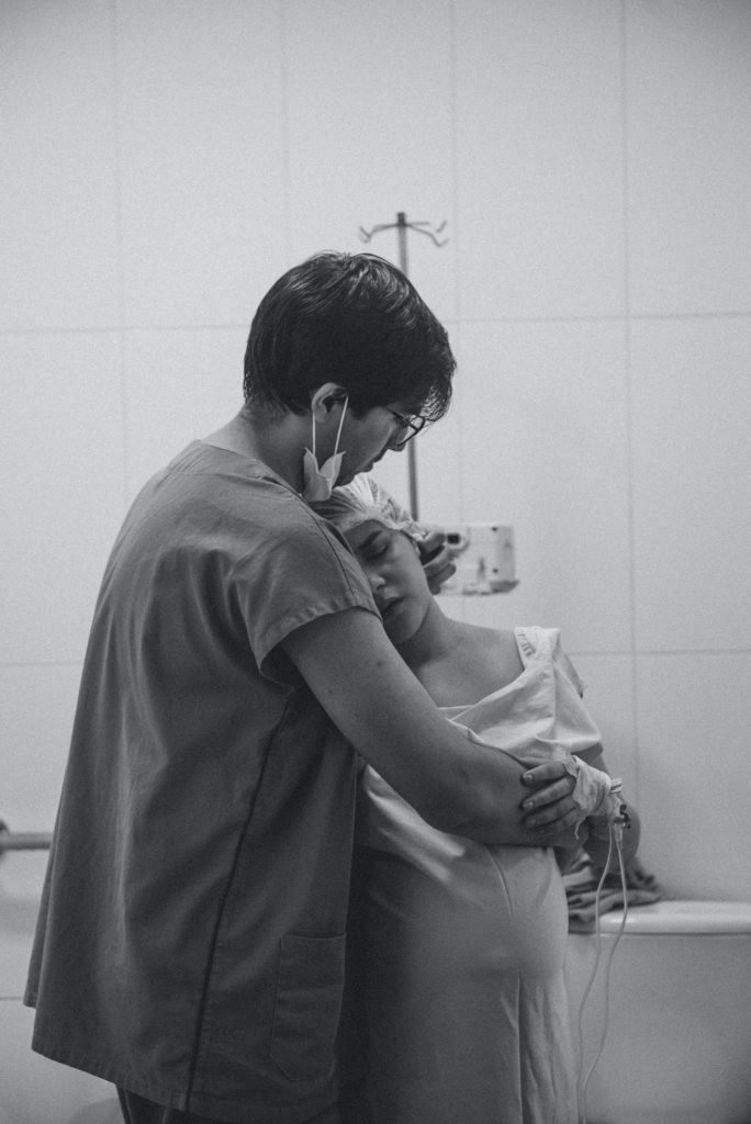A photograph of a husband embracing wife childbirth as a husband