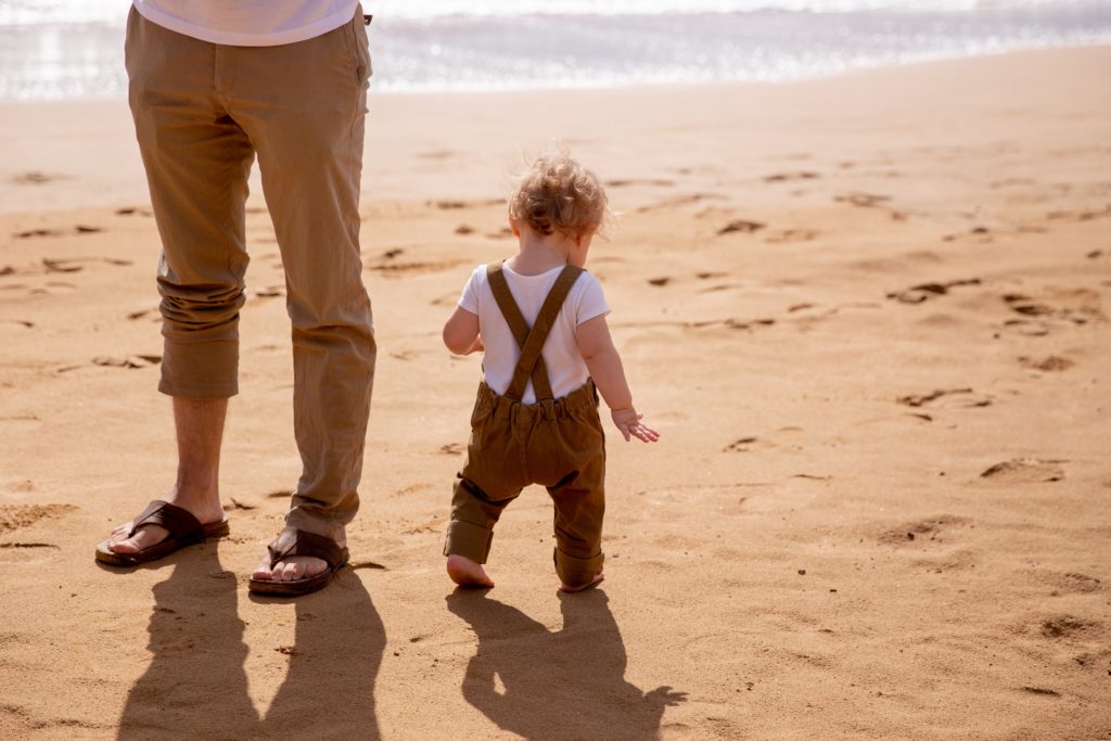 A photo of a baby on the beach with dad and choosing sunscreen for baby