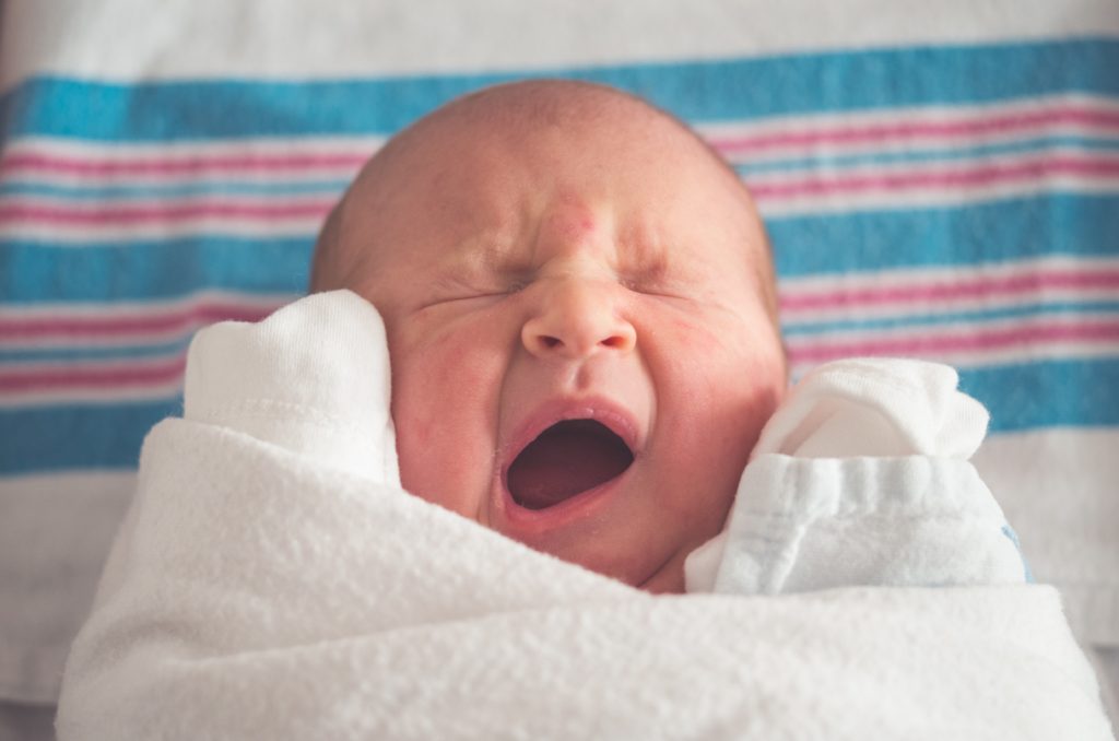 A baby yawning and baby spits up frequently