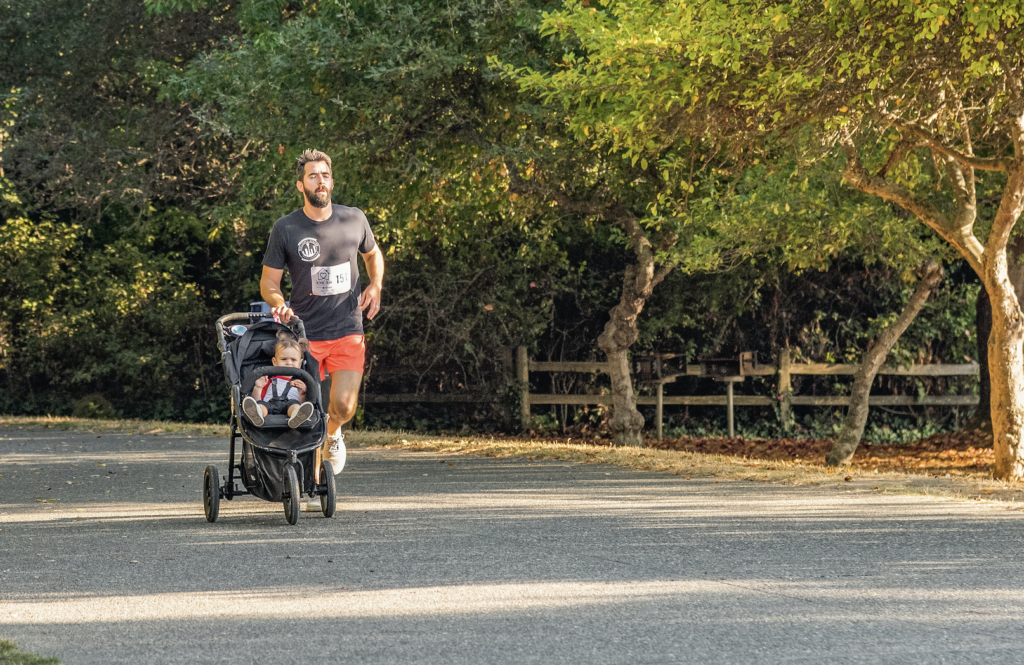 A man jogging with his baby with a jogging stroller