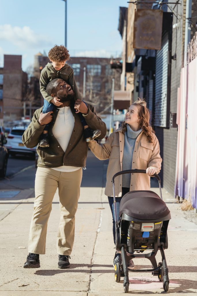 A diverse couple with a car seat stroller and baby