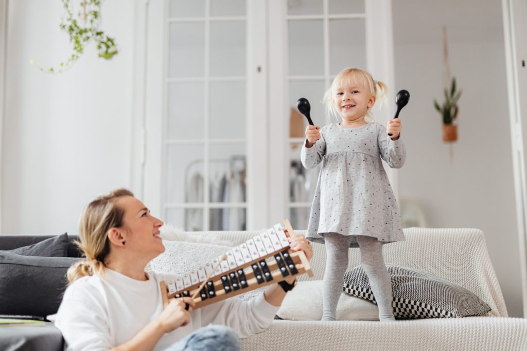 A toddler and her mom playing music for babies