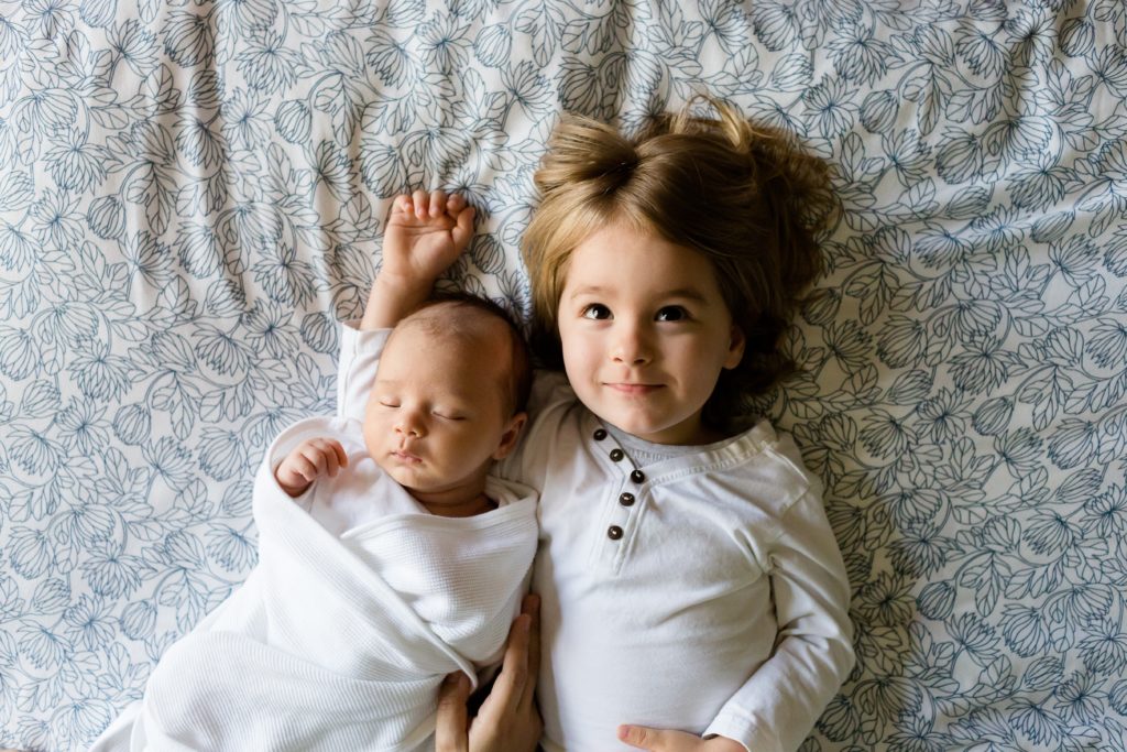 A newborn with a toddler. Newborn development from 6 to 12 months
